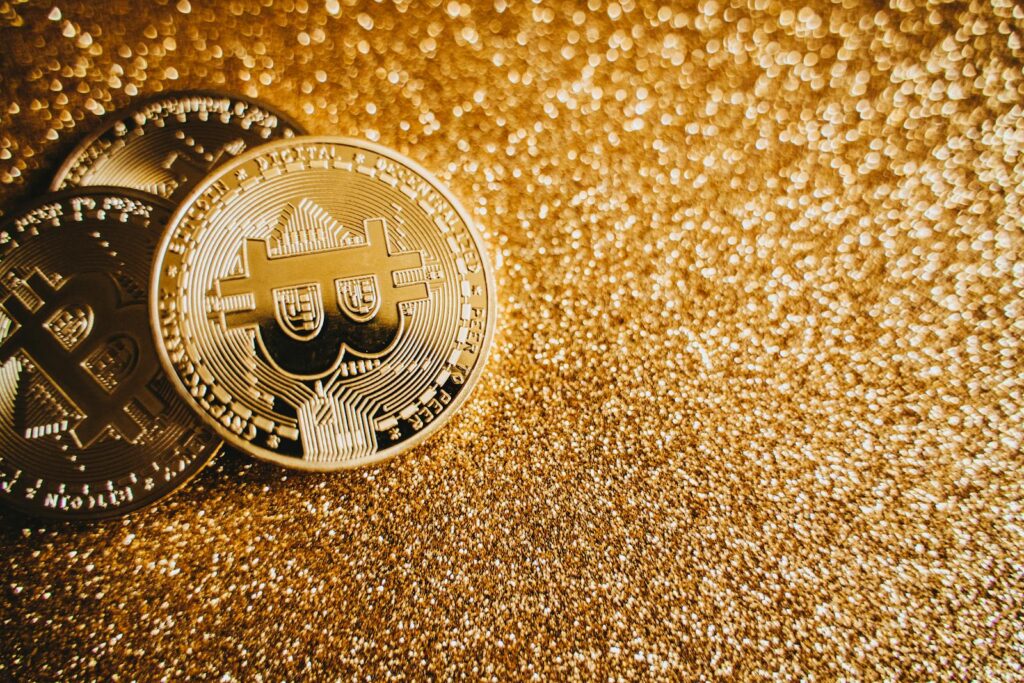 Close-up of bitcoins on a shimmering gold background, symbolizing digital wealth and investment.
